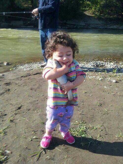 little girl hugging fish